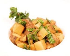 Bowl of chicken stew with potatoes and cilantro garnish