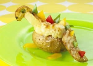 Dinosaur-shaped stuffed baked potato with colorful toppings.