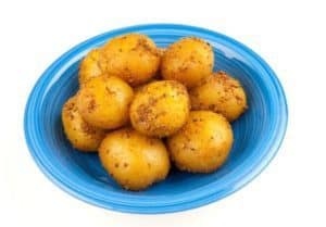 Blue plate filled with seasoned small yellow potatoes