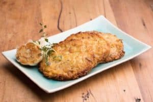 Golden brown potato pancakes served with garlic on plate