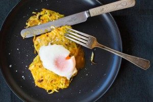 Fried egg on potato rösti with knife and fork