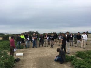Group of people attending outdoor agricultural field training session