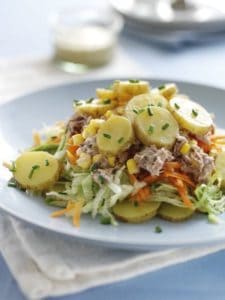 Plate of potato salad with tuna, corn, and lettuce.