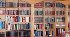Wooden bookshelf filled with colorful hardcover books and encyclopedias