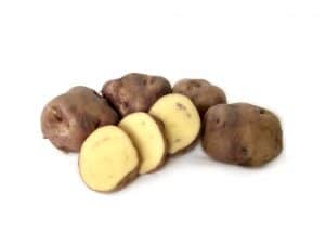 Purple-skinned potatoes with yellow flesh, whole and sliced.