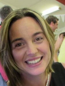 Smiling woman with blonde hair at indoor gathering