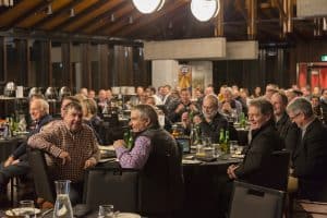 Group of people enjoying a social dinner event indoors