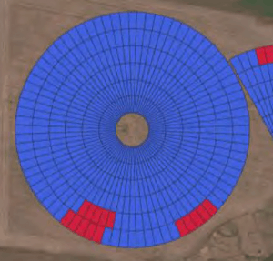 Aerial view of circular crop field with blue and red sections.