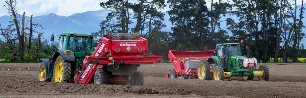 Temuka, Canterbury, New Zealand - September 14 2018: John Deere tractors and machinery on an agricultural farm preparing the soil for potato seeding