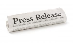 Rolled newspaper with the headline Press Release
