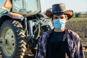 Hispanic young Farmer worker wearing a protective face mask due Covid-19 contagion prevention