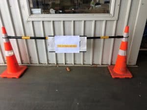 Two orange traffic cones with a two meters distance sign between them