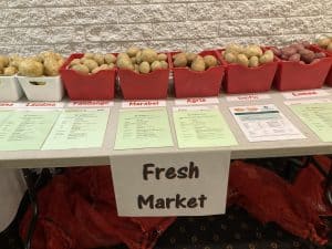 Variety of potatoes displayed in bins at fresh market table