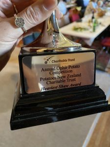 Hand holding trophy for heaviest potato award at New Zealand competition
