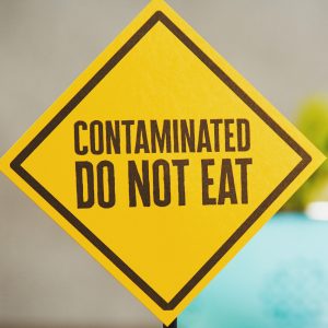 Yellow warning sign with text "Contaminated Do Not Eat"