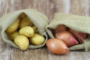 New potatoes and shallots in jute bags