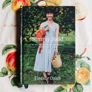 Cookbook "Simply Food" by Eleanor Ozich with woman holding basket outdoors