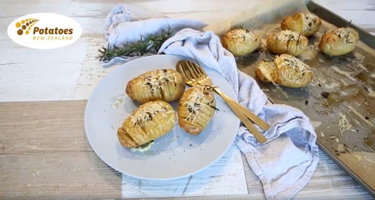 Golden baked hasselback potatoes with cheese and rosemary garnish