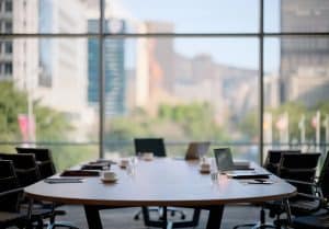 Chairs, table and technology in empty boardroom of corporate office for meeting with window view. Furniture, interior and still life desk with nobody in company workplace for professional career