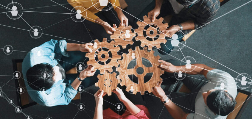 Top view of smart business people joining and gathering wooden gear. Symposium.