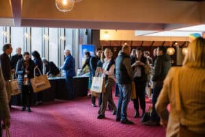 People networking at indoor business conference event venue.