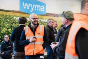 People wearing orange safety vests socializing at event