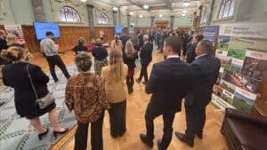 Business conference attendees listening to presentation in hall