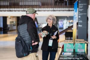 Woman handing out snack packets to man at event booth