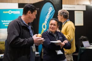 People networking and eating at a professional event booth