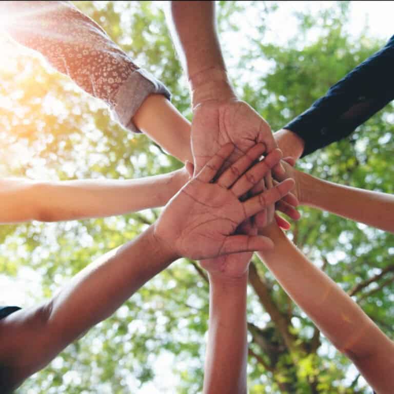 Group of diverse people stacking hands outdoors unity teamwork