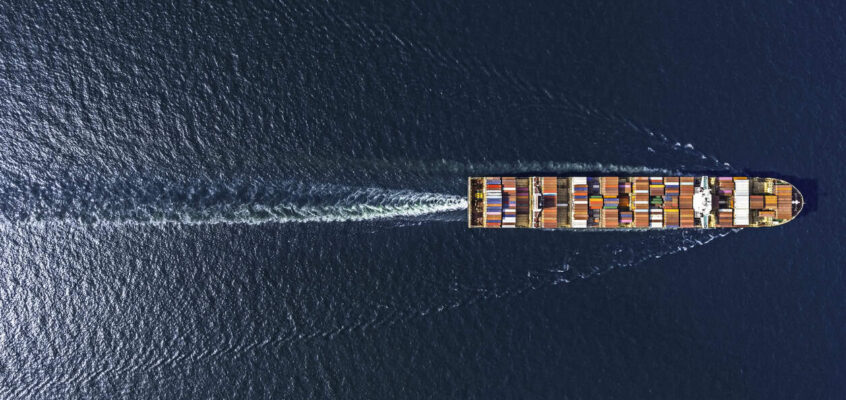 Aerial top view container ship in export and import business and logistics. Shipping cargo to harbor by crane.