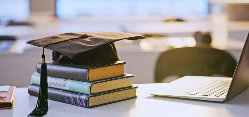 Graduation cap, books and laptop or university education for future goal, scholarship or online. Studying, research and thesis proposal for final school project for learning course, report or student