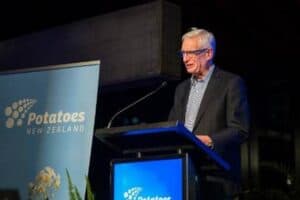 Man speaking at Potatoes New Zealand event podium.