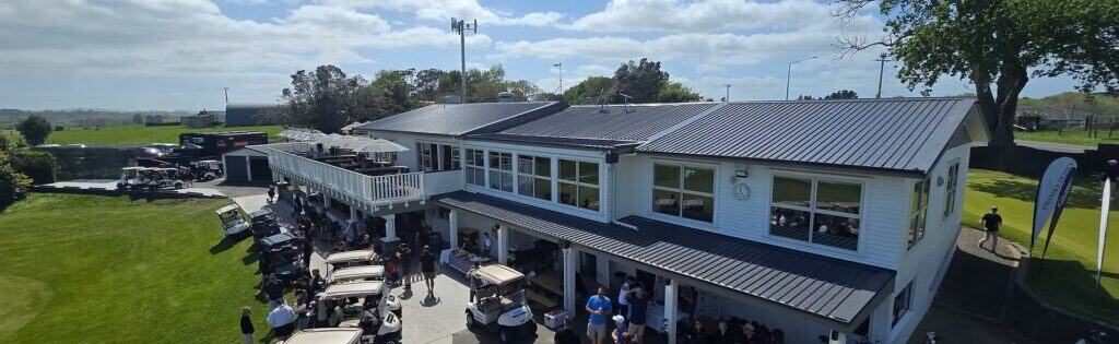 Golf clubhouse with carts and people on sunny day